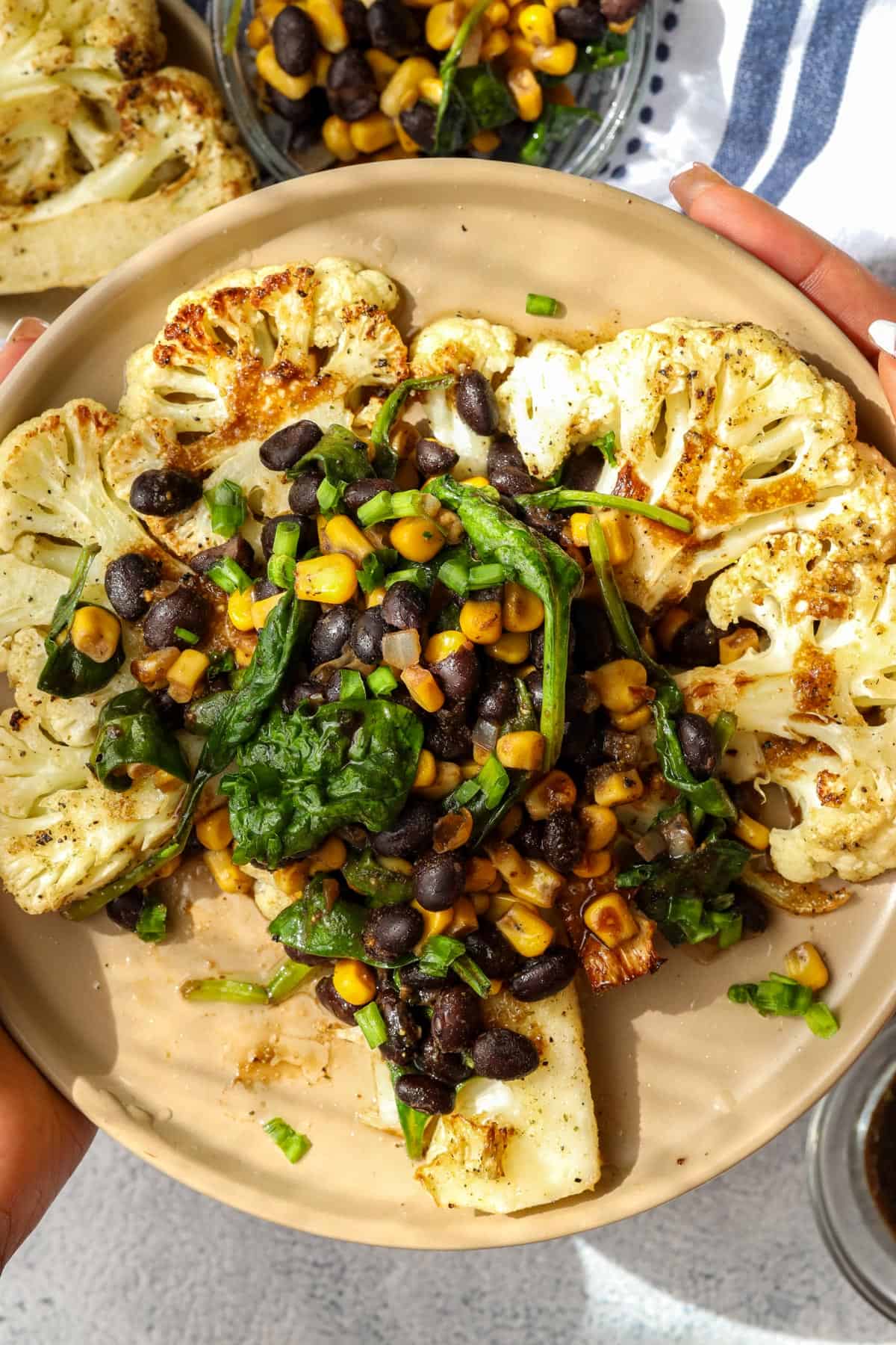 cauliflower steaks toped with black beans, corn, and spinach